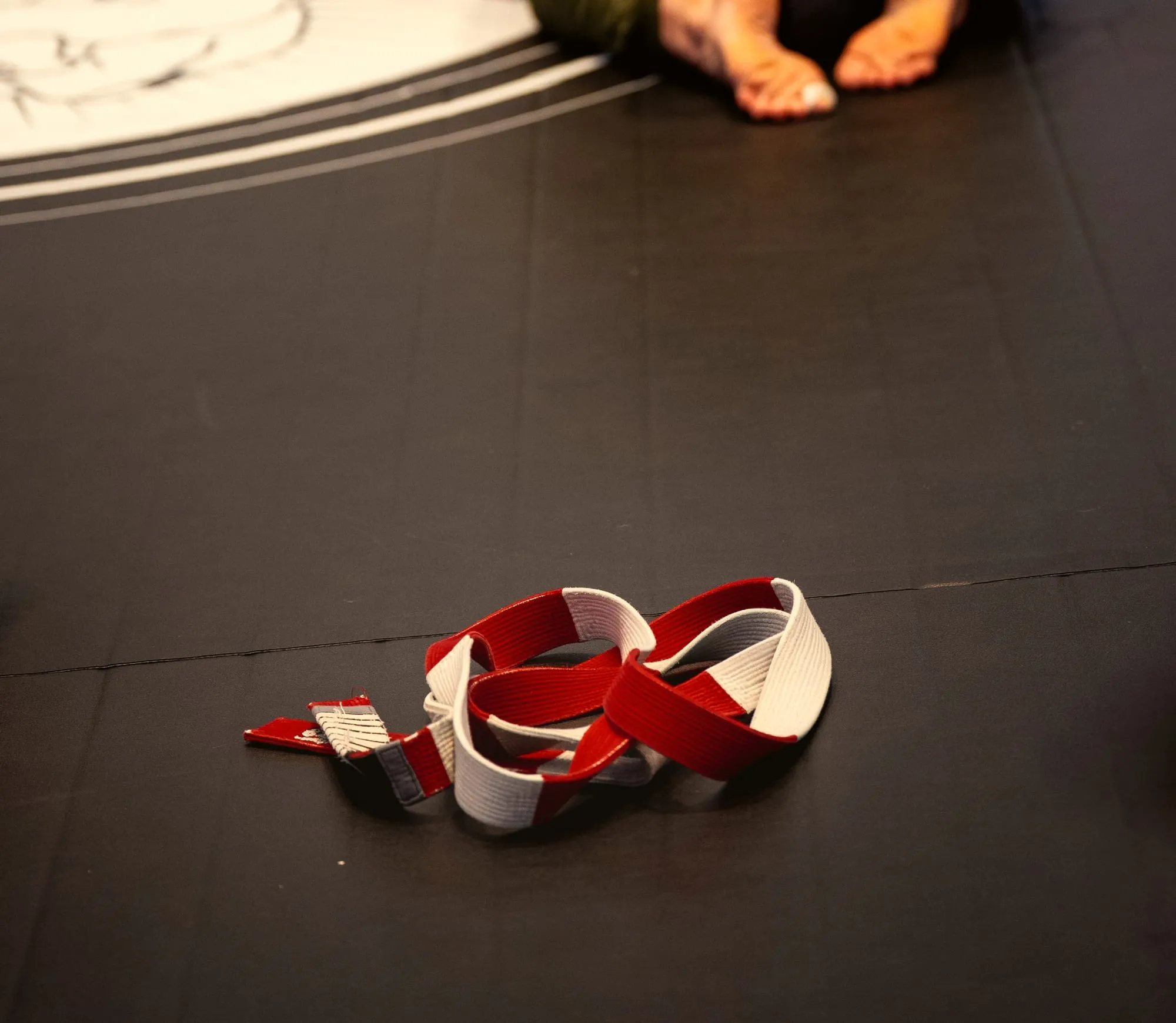 A red and white coral belt lying on the mat